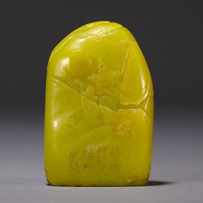 China - Yellow stone seal carved with a figure in a landscape and engraved with a poem.