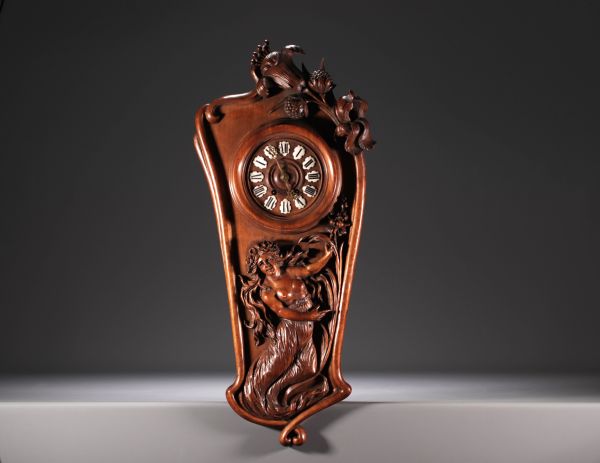 Art Nouveau clock in carved walnut with a half-dressed lady and floral decoration, enamel numerals, circa 1900.