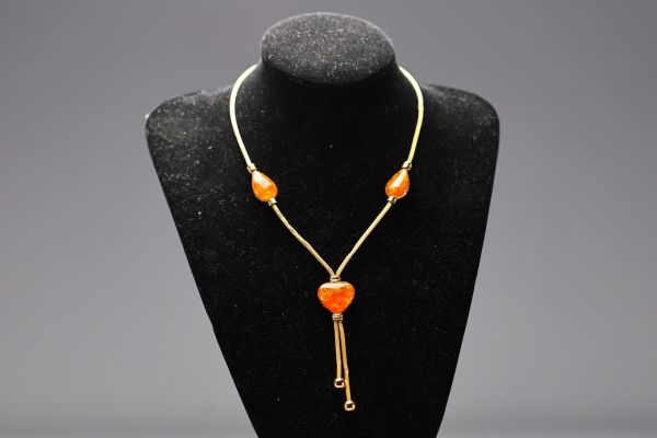 Yves SAINT LAURENT - Collier en coeur et gouttes en imitation ambre et métal doré, signé.