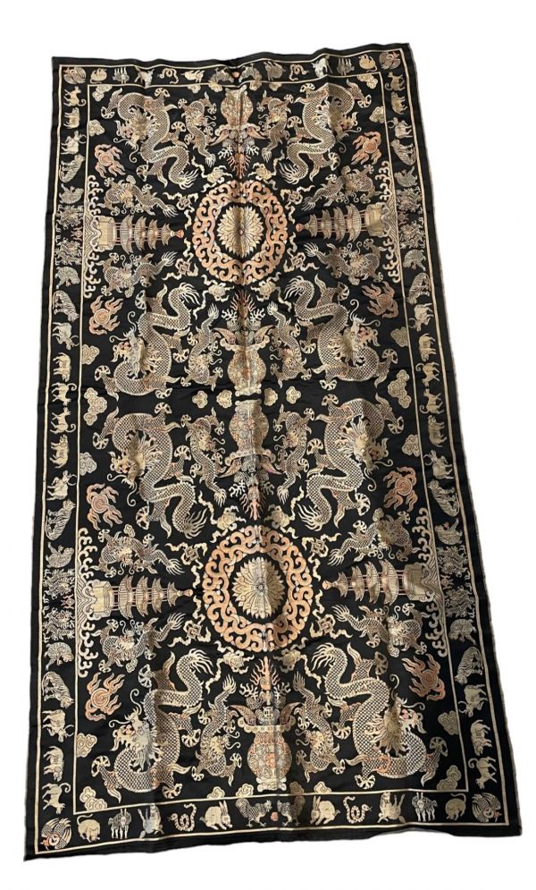 Tapis chinois brodé à décor de dragons et animaux sur fond noir.