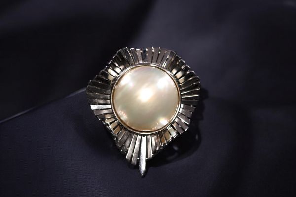 Grande perle montée sur un broche en or blanc pouvant également être portée en pendentif, poids total de 23gr.