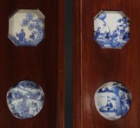 Chine - Suite de quatre panneaux ornés de seize porcelaines blanc bleu, époque Ming et Kangxi, XVIIIème.