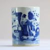 China - A white and blue porcelain brush pot decorated with dignitaries.