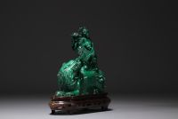 Chine - Sculpture en malachite représentant un chien de Fô et personnages, sur socle en bois.