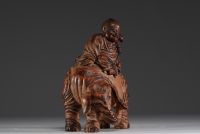 China - Buddha seated on an elephant, sculpture in patinated bamboo.