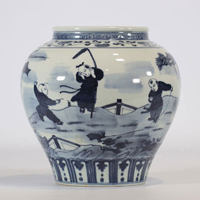 A white and blue porcelain vase with a landscape design