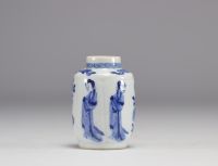 A small white and blue vase decorated with flowers and women in traditional dress from the Kangxi period (1661-1722) with a mark under the piece