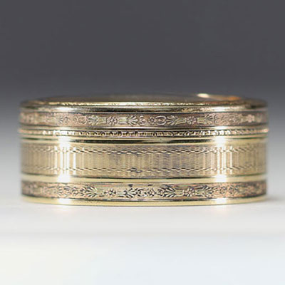 A solid silver snuffbox with a guilloche motif, the lid containing a miniature of flowers.