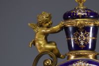 Rare pendule en porcelaine de Sèvres et bronze doré à décor d'angelots.