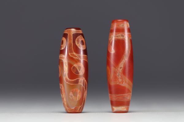 Tibet - Pair of Dzi amulets, one with ‘9 eyes’ in red agate, fine specimens from the 19th century.