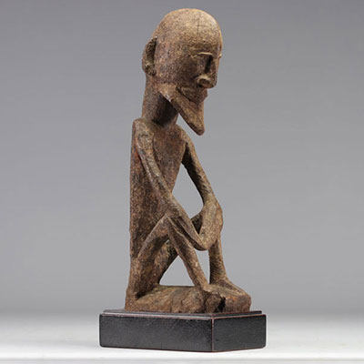 Dogon statue in carved wood representing a seated figure