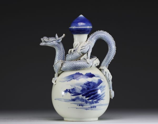 Japon - Théière en porcelaine blanc bleu à décor de paysage de montagnes et surmontée d'un dragon en relief, époque Meiji.