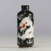 China - Porcelain snuffbox decorated with a dragon on a black background, Qianlong mark.