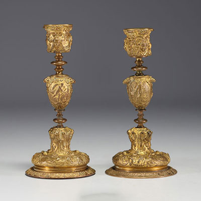 A pair of 19th century gilt bronze candlesticks, decorated with antique figures and goat heads.
