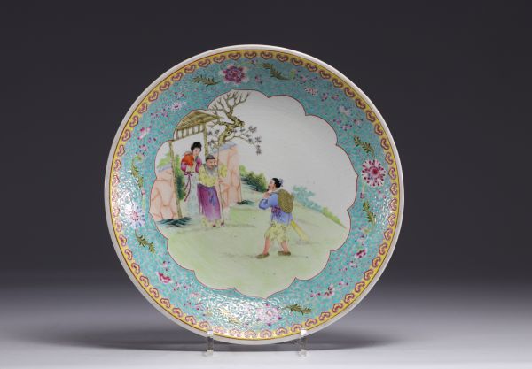 Chine - Assiette en porcelaine famille rose à décor de personnages au jardin, époque République.