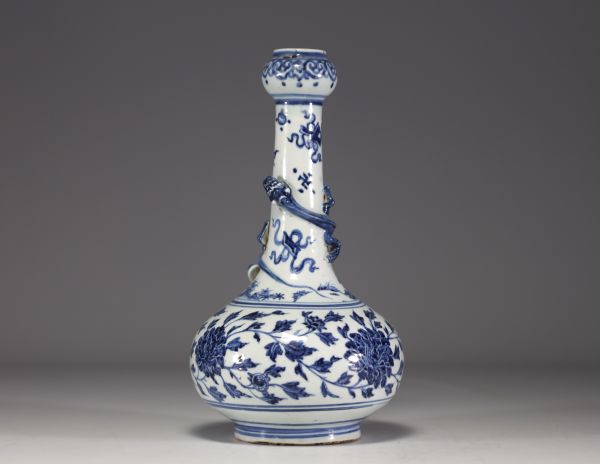 China - A white-blue porcelain vase decorated with a chimera in relief winding around the neck and floral motifs, 18th century.
