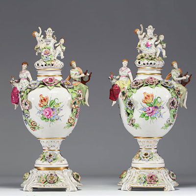 Pair of covered porcelain vases with rich polychrome decoration of figures and flowers in the Capodimonte style.