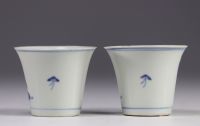 Pair of white and blue mugs decorated with  characters from the late 19th century