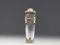 A rare solid silver and crystal perfume bottle decorated with musical instruments, foliage and flowers, the stopper representing a greyhound in vermeil, 19th century.