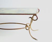 René DROUET (1899-1993) Table basse en fer forgé doré et plateau en verre églomisé, vers 1940