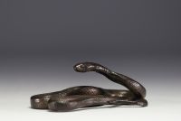 Patinated metal sculpture depicting a snake.