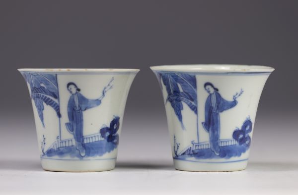 Pair of white and blue mugs decorated with  characters from the late 19th century