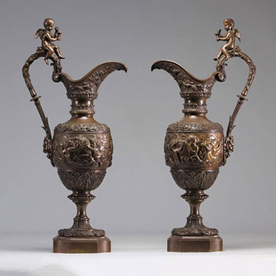 A pair of bronze ewers decorated with children figures in the style of Alphonse Giroux