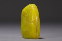 China - Yellow stone seal carved with a figure in a landscape and engraved with a poem.