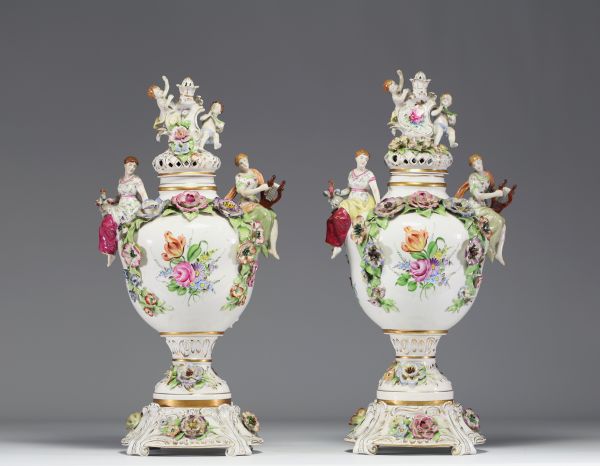 Paire de vases couverts en porcelaine à riche décor polychrome de personnages et de fleurs dans le goût de Capodimonte.