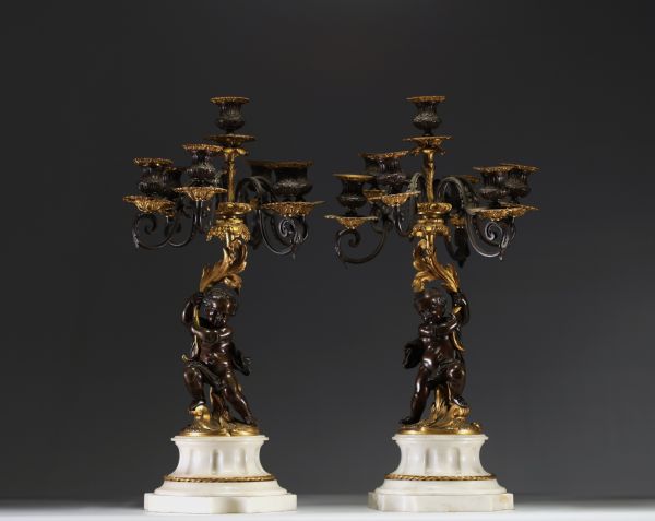 Paire de candélabres aux putti en bronze patiné et doré sur socle en marbre blanc, époque Napoléon III.