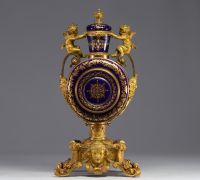 Rare pendule en porcelaine de Sèvres et bronze doré à décor d'angelots.