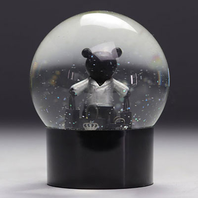 IKKS snow globe featuring a black teddy bear in a white T-shirt carrying luxury brand bags