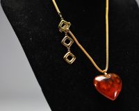 Yves SAINT LAURENT - Collier en coeur, imitation ambre et métal doré, signé.