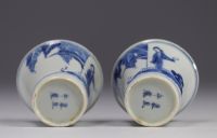 Pair of white and blue mugs decorated with  characters from the late 19th century