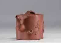 China - Yixing teapot in terracotta with floral decoration in relief, debossed mark on the underside.