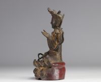 Statue of a traditional seated figure in bronze originating from China from the Ming period  (明朝)