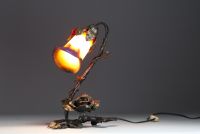 Table lamp, wrought iron base with floral decoration, orange and blue glass paste wick, circa 1900-20.