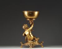 Christofle - Présentoir en bronze doré représentant un putto assis sur une souche recouverte de pampres, poinçons et marque sous la pièce.