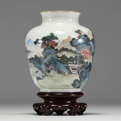 Chine - Vase en porcelaine polychrome à décor de paysage, socle en bois, marque au bleu sous la pièce.