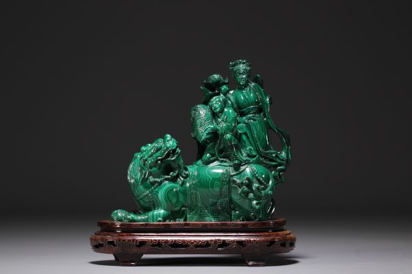 Chine - Sculpture en malachite représentant un chien de Fô et personnages, sur socle en bois.