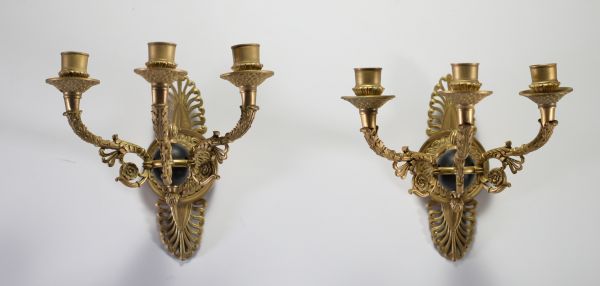 Paire d'appliques murale à trois bras de lumière en bronze doré aux mufles de lion, de style Empire, début XIXème.