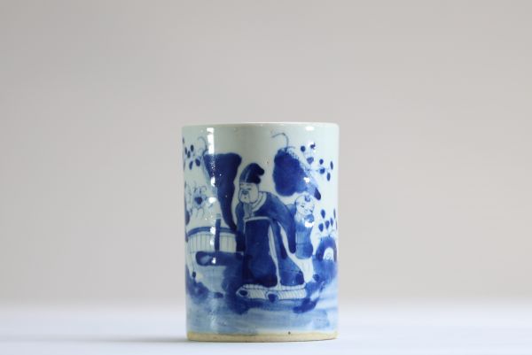 China - A white and blue porcelain brush pot decorated with dignitaries.