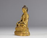 Sculpture of a seated Buddha on a gilded bronze base