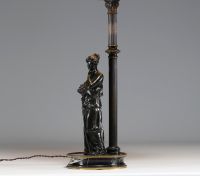 Lampe en bronze représentant une femme à l'antique adossée sur une colonne, socle en marbre noir.