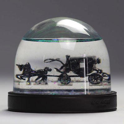 COACH snow globe depicting a horse-drawn carriage with two glittery horses