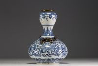 China - A white-blue porcelain vase with floral decoration surmounted by two bronze chimeras.