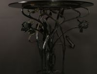 Glass table with floral wrought iron base, Art Nouveau period.