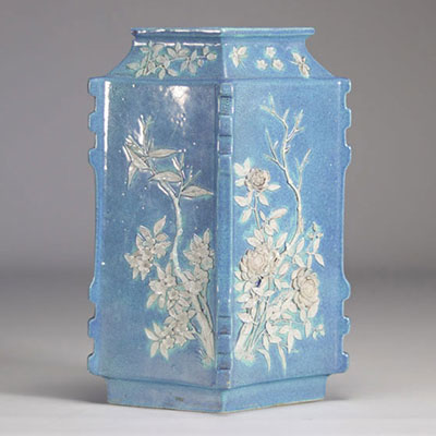 A Chinese porcelain vase decorated with flowers in relief on a light blue background from Qing period (清朝)