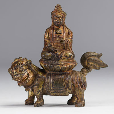 An ormolu Guanine sculpture resting on a lion from the Qing period (清朝)