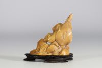 China - Hard stone sculpture of a figure with a lion on a wooden base.